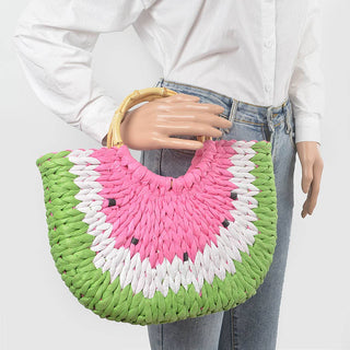 Person holding a colorful woven handbag with a watermelon design.