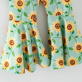 Light blue pants with sunflower pattern on a light gray background