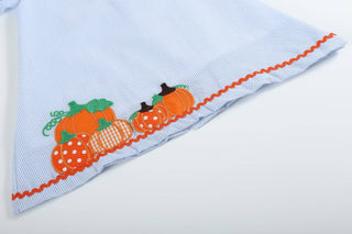 Light blue fabric with orange and green embroidered pumpkins on a white background
