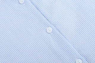 Close-up of a light blue striped fabric with white buttons.