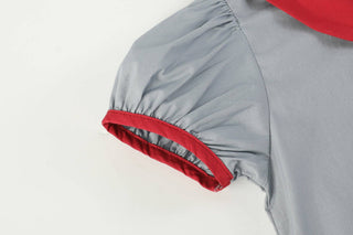 Gray raincoat with red interior lining on a light gray background