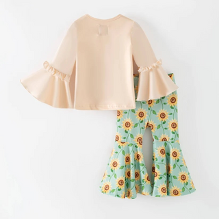 Beige top and sunflower-patterned pants on a white background