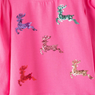 A close-up of a bright pink garment featuring five sequined reindeer appliqués in purple, green, pink, orange, and gold.